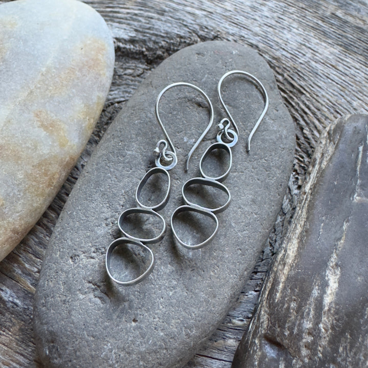 Handmade oxidized sterling silver cairn dangle earrings on river rock, lightweight nature-inspired jewelry, made in Colorado.