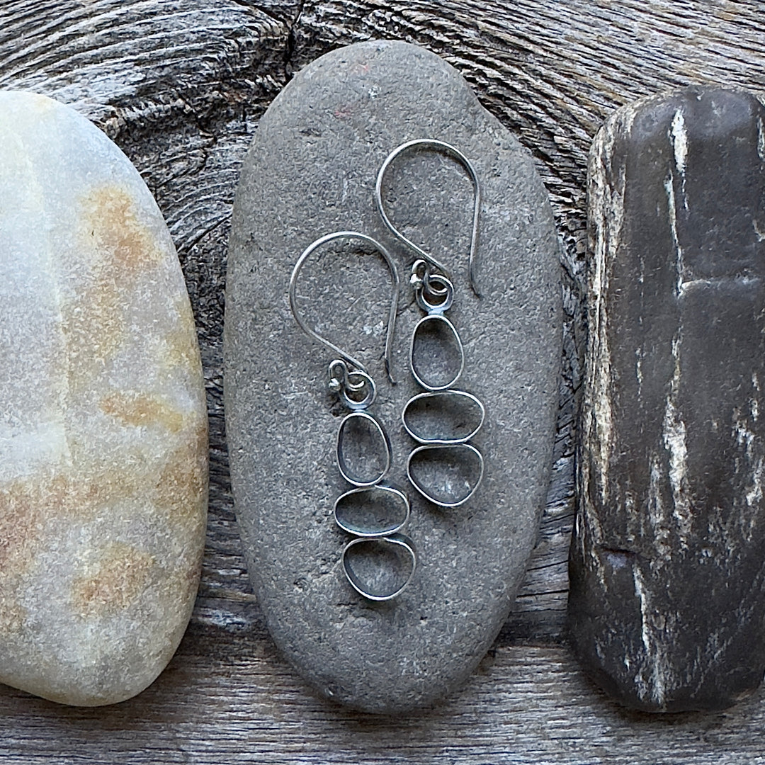 Handmade oxidized sterling silver cairn dangle earrings on river rock, lightweight nature-inspired jewelry, made in Colorado.