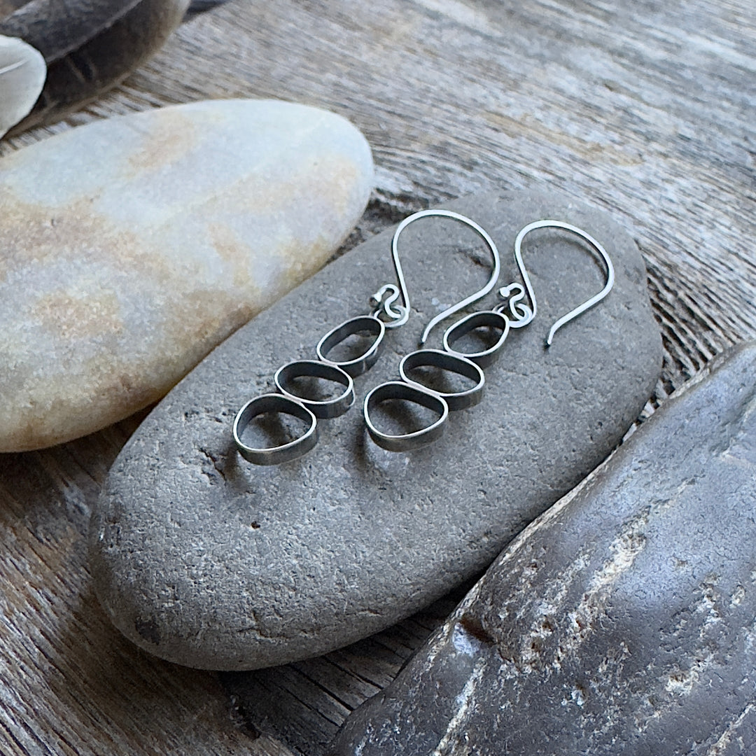 Handmade oxidized sterling silver cairn dangle earrings on river rock, lightweight nature-inspired jewelry, made in Colorado.
