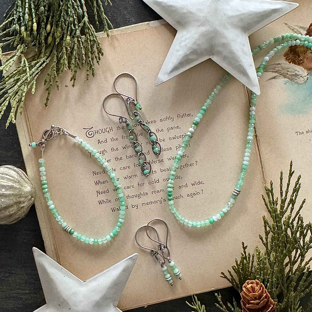 Frosted Mint chrysoprase bracelet, necklace, and earrings with Thai silver accents on a vintage holiday book with greenery and white star decor.