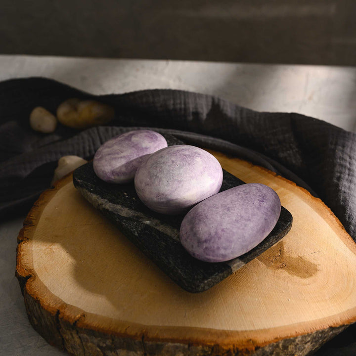 Jane River Stone Salt Soap Trio in black soap dish on wood slab.