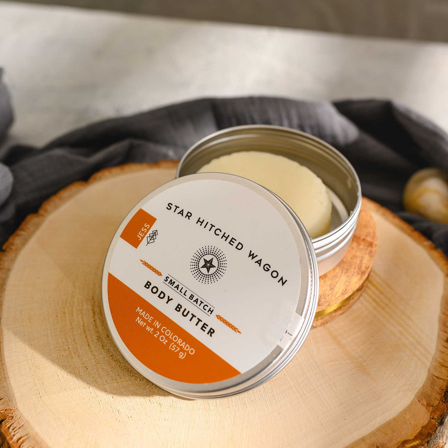 Jess body butter moisturizer in reusable tin, crafted with organic oils and butters to nourish dry skin. Scented with tangerine and patchouli.