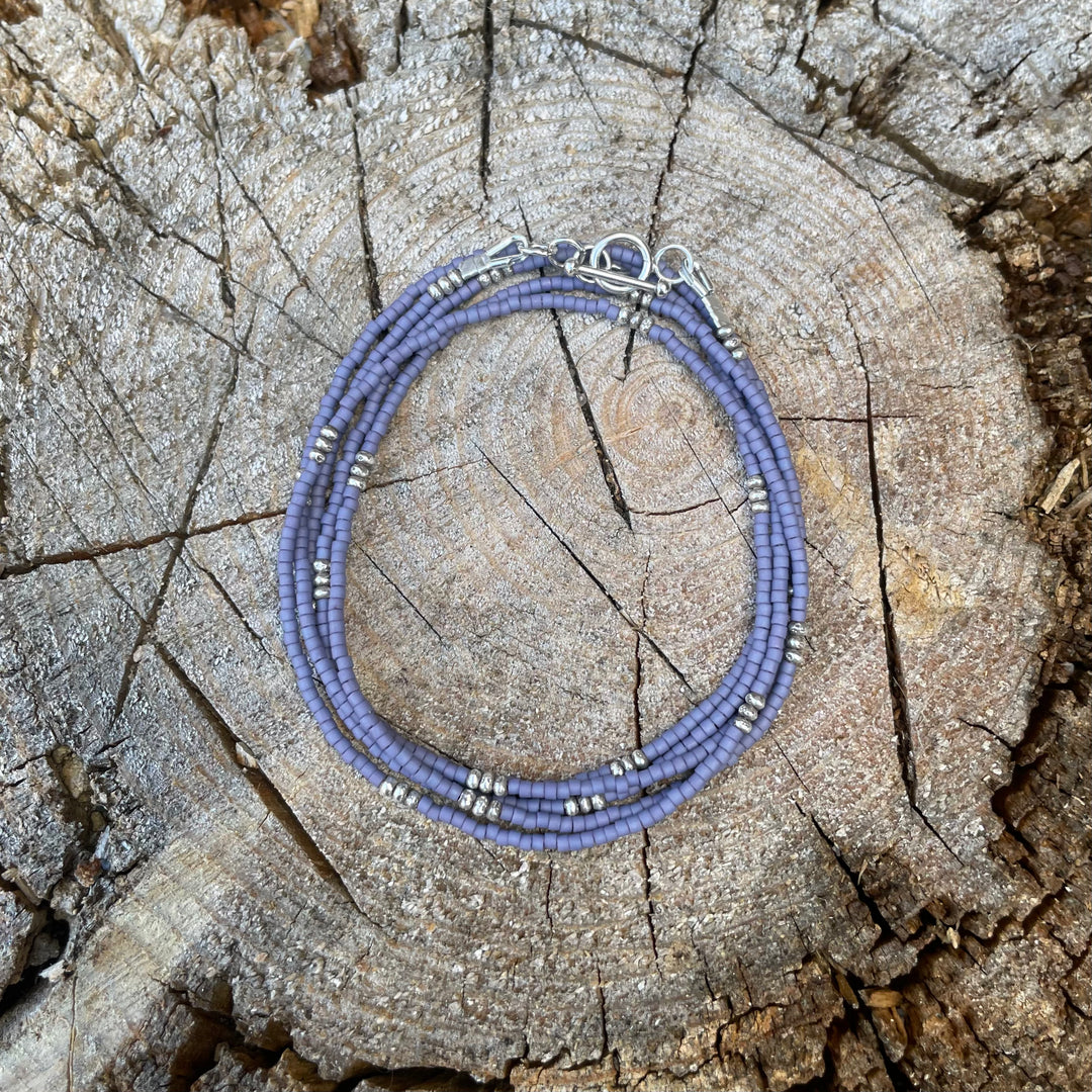 Matte lavender seed bead wrap bracelet on wooden background