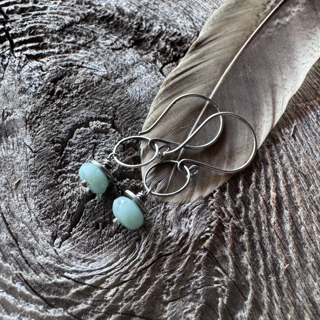 Amazonite and sterling silver earrings on a textured wooden surface with a feather.