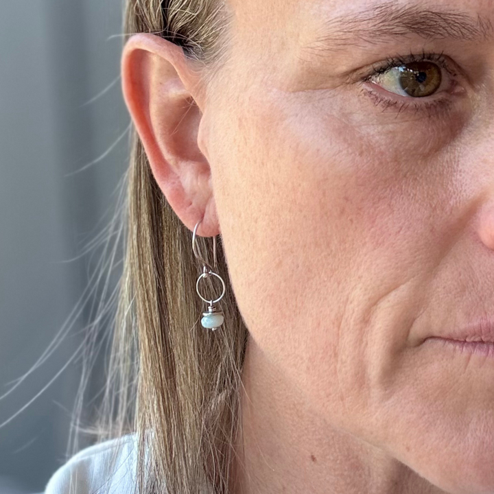 Close-up of a woman wearing a pair of amazonite and silver earrings 