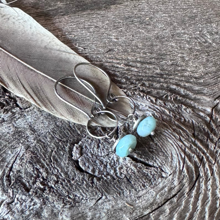 Amazonite and sterling silver earrings on a textured wooden surface with a feather.