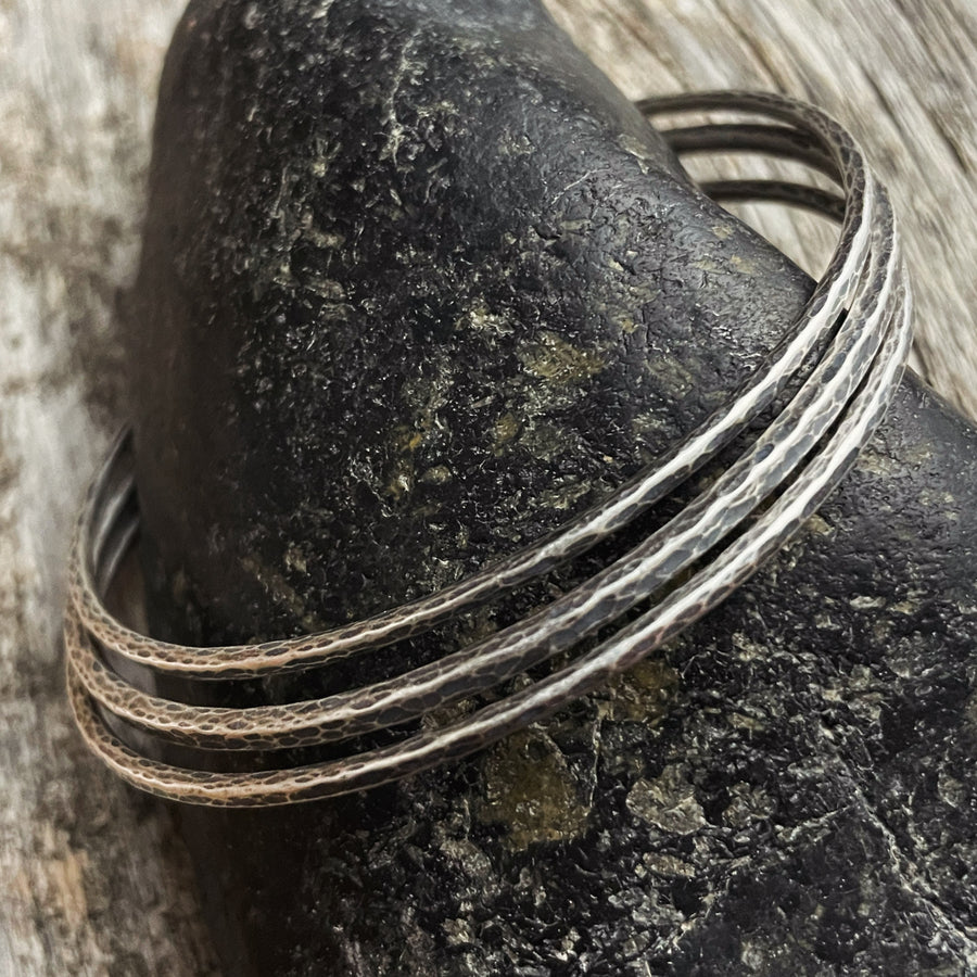 Sterling Silver Bangles - Rustic Handmade Trio on a black rock
