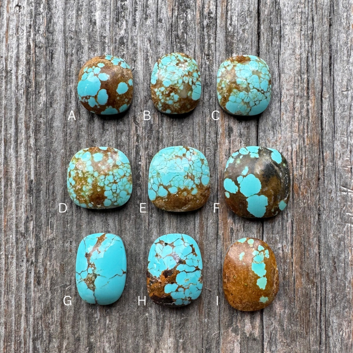 The Drift Ring Turquoise Stone choices on a wooden surface .